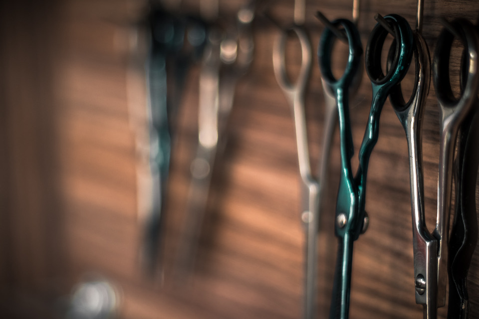 Row of barber scissors hanging on a wall